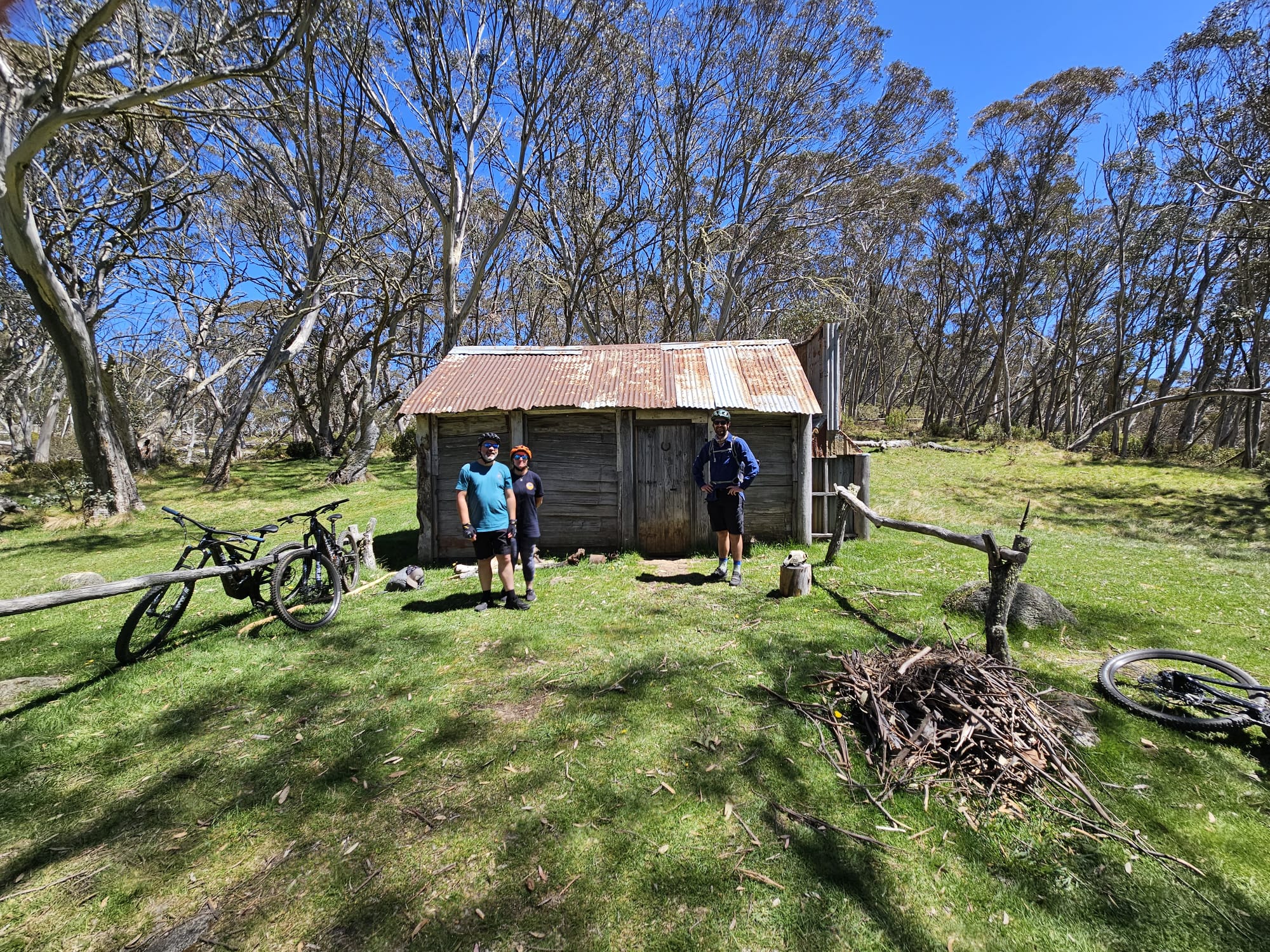 Two people with bikes standing infront of a hut